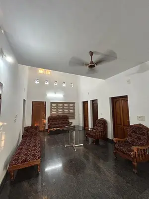 a living room with chairs and a ceiling fan at Entire 4BHK House with Full Kitchen near malayattoor in Kodanad