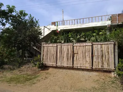 a wooden fence in front of a building with a bridge at SHI's Triveni Spacious 2BHK Villa in Pappampatti in Chettipālaiyam