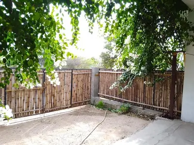 a wooden fence with white flowers on it at SHI's Triveni Spacious 2BHK Villa in Pappampatti in Chettipālaiyam