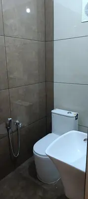 a bathroom with a white toilet and a sink at Metta Heaven in Kodenchery