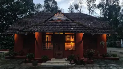 a small red house with a roof at Heritage Mudhouse Homestay in Virajpet