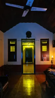 a hallway with a yellow door in a room at Heritage Mudhouse Homestay in Virajpet