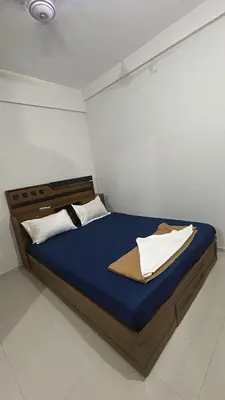 a bedroom with a bed with blue sheets and white pillows at 1bhk Kalp 200m temple Thulasi nagar in Guruvāyūr