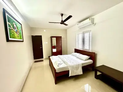 a bedroom with a bed and a ceiling fan at BR Farm Stay in Coimbatore