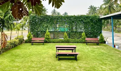 three benches sitting on the grass in a park at BR Farm Stay in Coimbatore