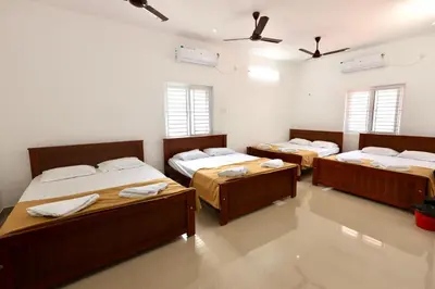 a room with four beds in it with windows at BR Farm Stay in Coimbatore