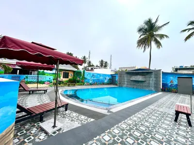 a swimming pool in a resort with a palm tree at BR Farm Stay in Coimbatore