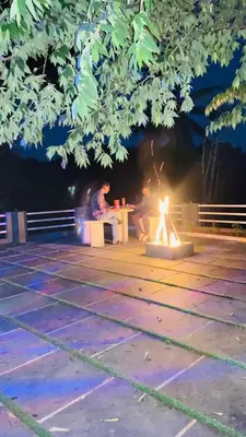 a group of people sitting around a table at night at The Wayanad Stays in Kalpetta