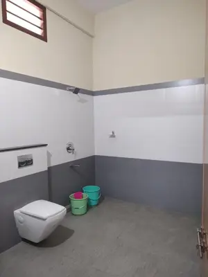 a bathroom with a toilet and two buckets at Bridgettine Paradise in Sultan Bathery