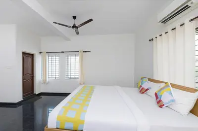 a bedroom with a large bed with a ceiling fan at Stayz Royale - Mysuru near Mysuru Palace in Mysore