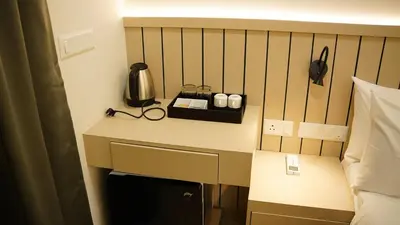 a room with a bed with a desk in a room at VOX holiday in Palakkad