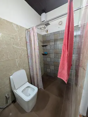 a bathroom with a toilet and a shower at Eva's Homestay at Cherai in North Paravur