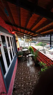 an outside patio with a table and chairs and plants at Steeva service apartment in Mysore