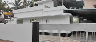 a white house with a fence in front of it at Ivory Suites Meadows in Kozhikode