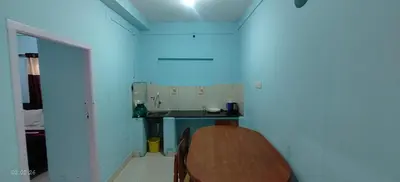 a small kitchen with a table and a blue wall at Jay bahadur Cottages and home stay in Ooty