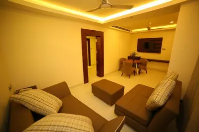 a living room with a couch and a table at Vavas Inn & Suites in Perintalmanna