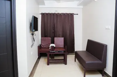 a living room with a couch and a chair at Gokulam suits guruvayur in Guruvāyūr