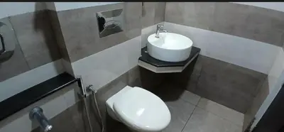 a bathroom with a sink and a toilet at Gokulam suits guruvayur in Guruvāyūr