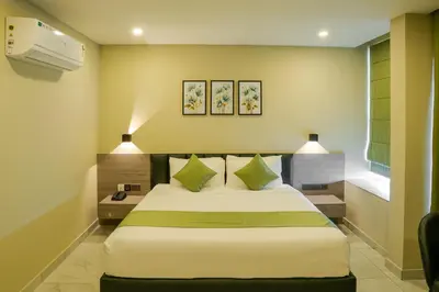 a bedroom with a large bed with green pillows at Chaliyar Resorts