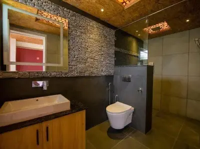 a bathroom with a sink and a toilet and a mirror at ivaana resorts mysore in Mysore