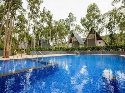 a large blue swimming pool in front of a house at ivaana resorts mysore in Mysore