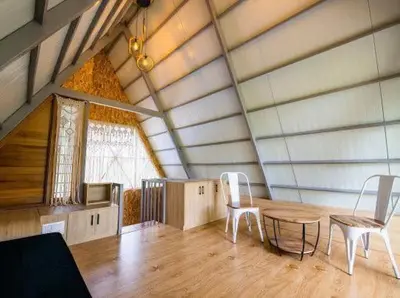 a room with a table and chairs in a attic at ivaana resorts mysore in Mysore