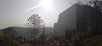 a building on top of a hill with the sun behind it at Spirit of the Wild Mountain Retreat in Attappādi