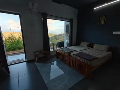 a bedroom with a bed and a large window at Spirit of the Wild Mountain Retreat in Attappādi