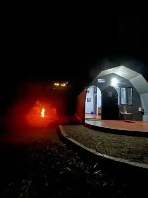 a cave with a fire in it at night at Spirit of the Wild Mountain Retreat in Attappādi