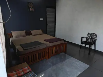 a bedroom with a bed and a chair in it at Spirit of the Wild Mountain Retreat in Attappādi