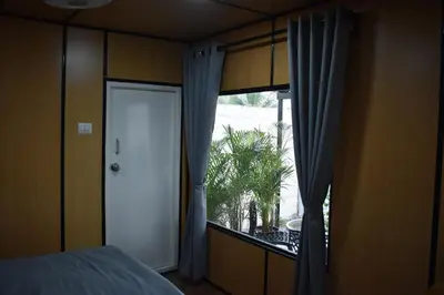 a bedroom with a bed and a window with curtains at GUDU by Coexist in Mysore