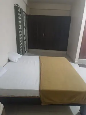 a large bed in a room with a window at Shreyas Residency in Mysore