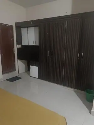 a bedroom with wooden cabinets and a bed in it at Shreyas Residency in Mysore