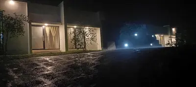 a house at night with lights on a street at Metta Heaven Farm Resort in Kodenchery