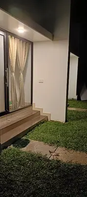 a house with a window with a curtain on it at Metta Heaven Farm Resort in Kodenchery