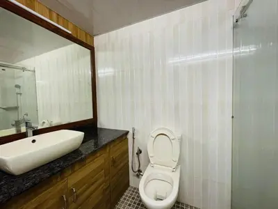 a bathroom with a sink and a toilet and a mirror at Lush Orchard in Kizhake Chālakudi