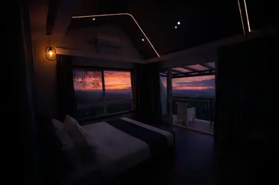 a bedroom with a bed and a large window at Ymoon Mountain Resort Wayanad in Koroth