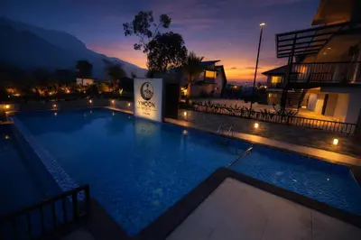 a large swimming pool at night with a building at Ymoon Mountain Resort Wayanad in Koroth