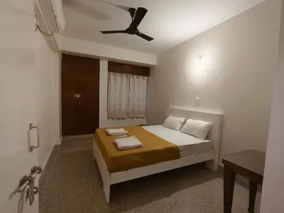 a bedroom with a bed with a ceiling fan at Raviudaya-2bhk in Mysore