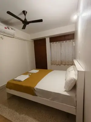a bedroom with a bed with a ceiling fan at Raviudaya-2bhk in Mysore