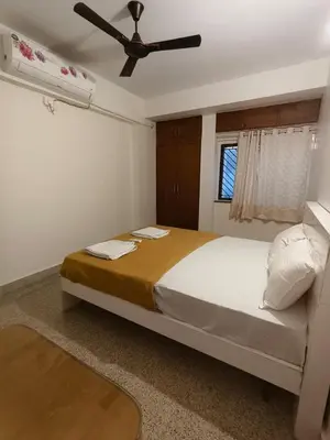 a bedroom with a large bed with a ceiling fan at Raviudaya-2bhk in Mysore