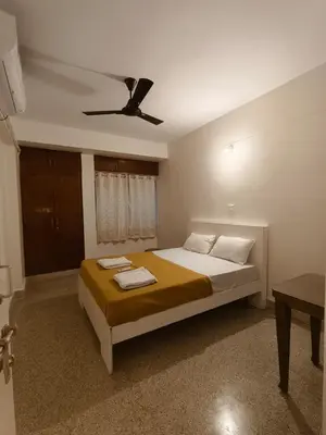 a bedroom with a bed with a ceiling fan at Raviudaya-2bhk in Mysore