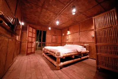 a bedroom with a large bed in a wooden room at Bali bamboo in Padinjarathara