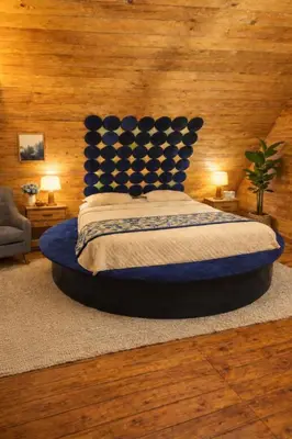 a bedroom with a large bed with a blue headboard at The Farmville kodaikanal in Kodaikānāl