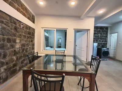 a dining room with a glass table and chairs at Sunflower Villa Cottage Coonoor in Coonoor