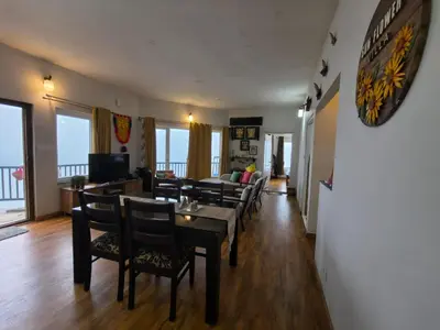 a living room with a dining table and chairs at Sunflower Villa Cottage Coonoor in Coonoor