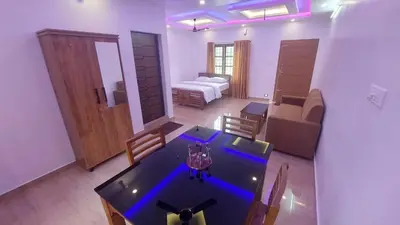 a room with a dining table and a living room at Caramel stay in Marayoor
