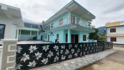 a house with a black and white wall at Caramel stay in Marayoor