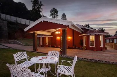 a table and chairs in front of a house at Wyncroft Bed and Breakfast, Heritage Bungalow at Kotagiri in Kotagiri