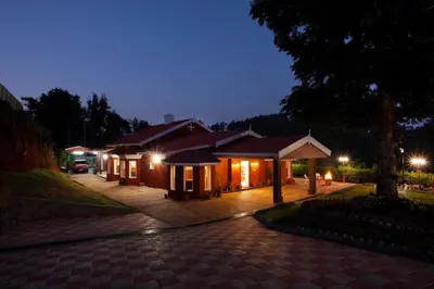 a night view of a building with lights at Wyncroft Bed and Breakfast, Heritage Bungalow at Kotagiri in Kotagiri